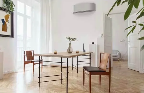 Ljust rum med en vit värmepump på väggen